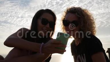 两个漂亮的白人女孩在智能手机上看<strong>搞笑视频</strong>。 生活方式HD慢速运动。